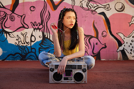 中国有嘻哈街头美女使用老式播音机背景