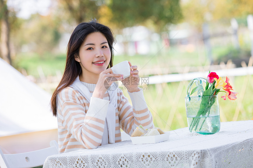 在户外捧着茶杯的女性图片