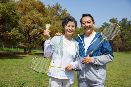 老年夫妇在公园打羽毛球高清图片