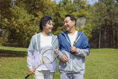 老年夫妇在公园打羽毛球高清图片