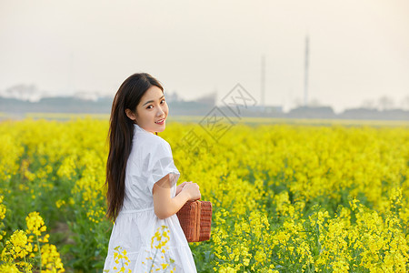 在油菜花田散步的年轻女性图片素材