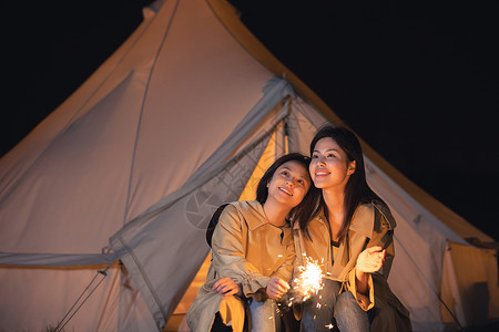 在帐篷外放烟花的闺蜜两人背景图片