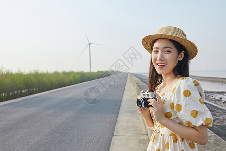 春天女孩可爱图片户外拿着照相机的文艺女青年背景