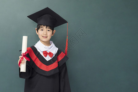 穿着学士服的小男孩递出毕业证书高清图片