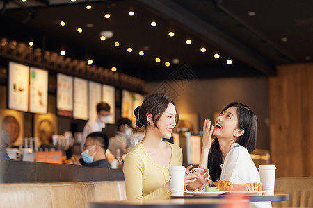 在咖啡店开心大笑的年轻女性图片素材