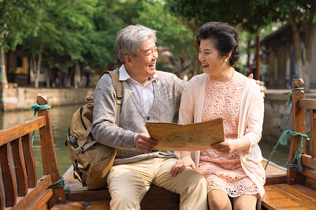 老人旅行素材老年夫妻古镇游船看地图背景