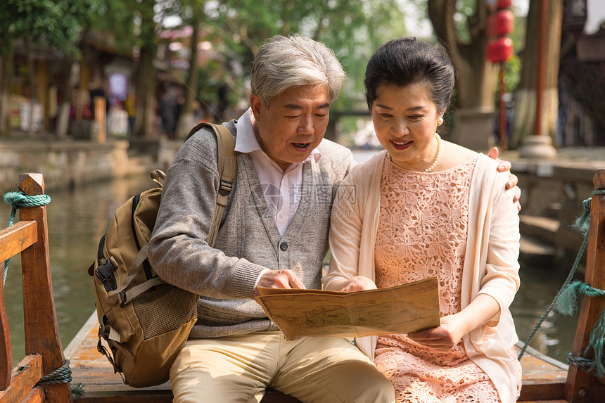 老年恩爱夫妻游船上看地图图片