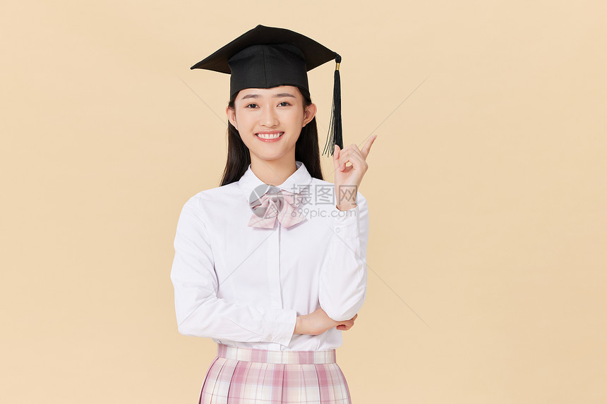 带着学位帽的女生手举毕业证书庆祝毕业