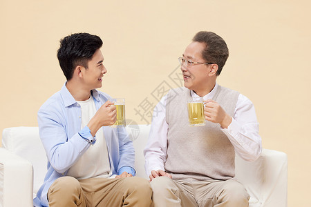 中年父子沙发上喝啤酒图片