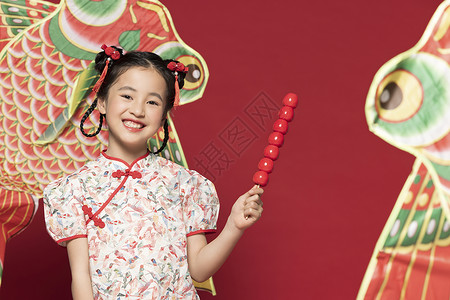 中国流行女歌手拿着冰糖葫芦笑得很开心的小女孩背景