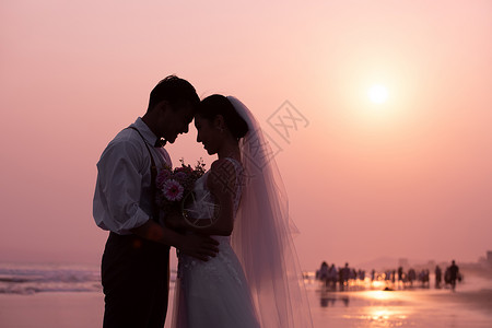海边婚纱照海边沙滩夫妻日落剪影背景