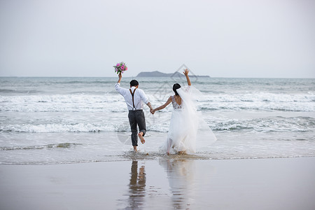 海边沙滩情侣夫妻奔向大海背景