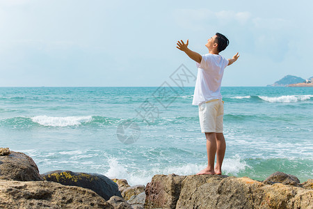 夏季男孩背影青年男性张开手臂拥抱大海背影背景