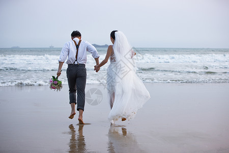 海边沙滩情侣夫妻奔向大海图片