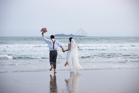 海边沙滩情侣夫妻奔向大海背景