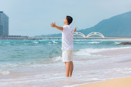 夏季男孩背影青年男性张开手臂拥抱大海背影背景