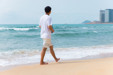 海边沙滩青年男性旅行散步背影图片