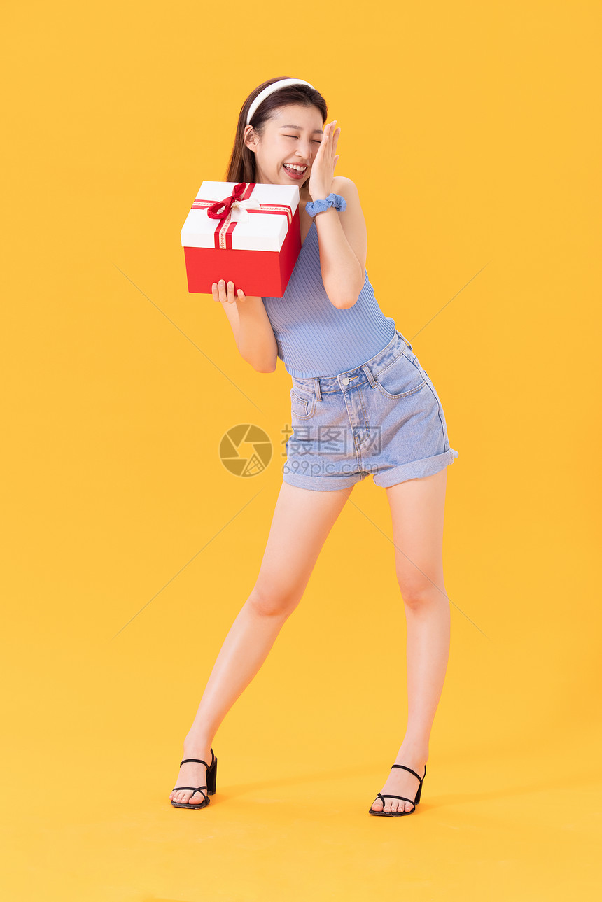 抱着礼物盒的年轻女性图片