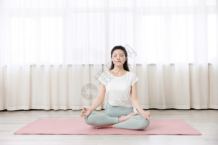 年轻女性瑜伽垫上休息女性瑜伽打坐休息背景