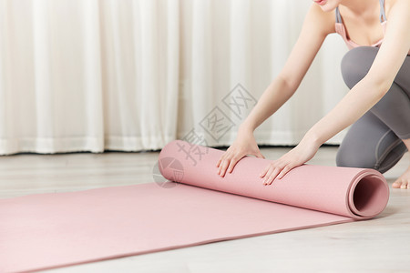 女性瑜伽锻炼整理瑜伽垫高清图片