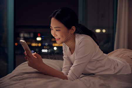 微信素材中国青年女性深夜睡前躺床上玩手机背景