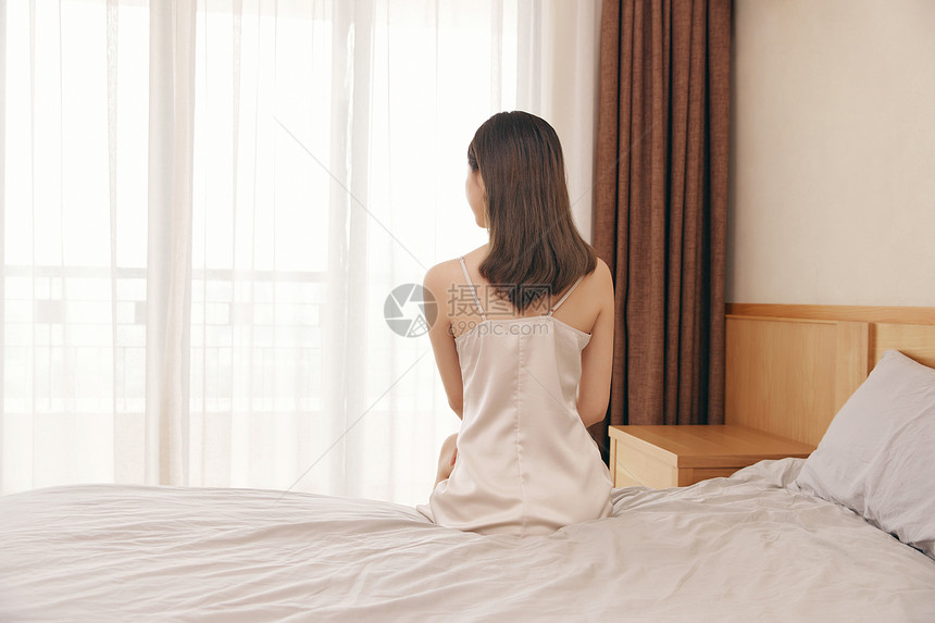 睡衣单身美女坐在床上背影图片