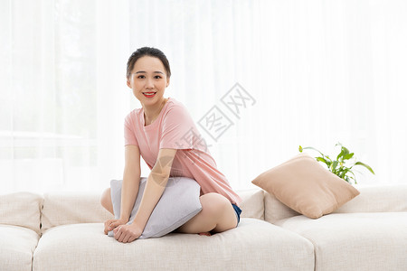 青年女性坐沙发上居家休闲生活背景图片