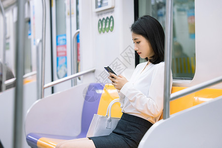地铁上看手机的女性上班族高清图片素材