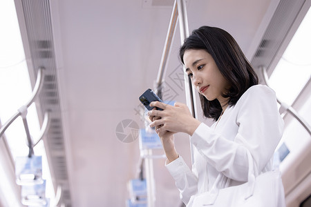 乘坐地铁看手机的女性亚洲人高清图片素材