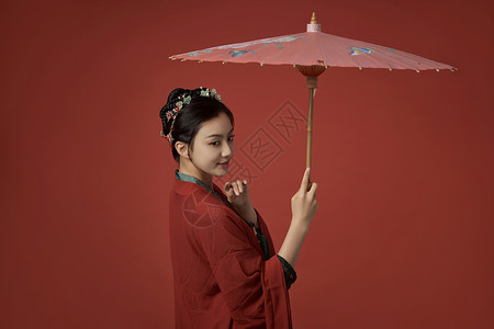 撑着伞女孩撑着伞的古装唐朝服饰美女回眸微笑背景