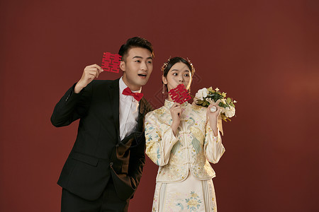 年轻情侣拿着喜字拍中式婚纱照图片素材