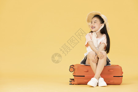 坐在行李箱上的小女孩背景图片