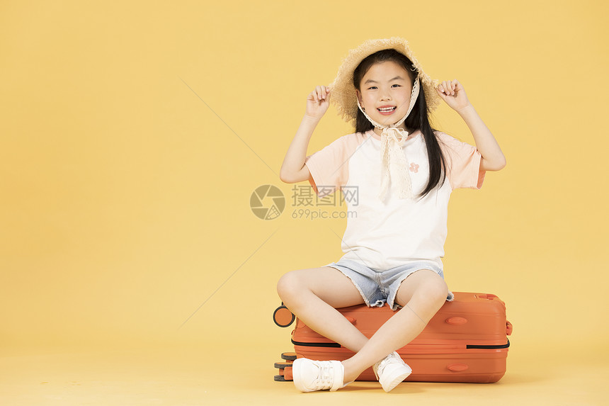 坐在行李箱上的小女孩图片