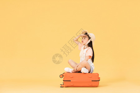 坐在行李箱上眺望远方的小女孩背景图片