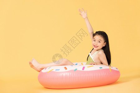 夏日泳装清凉儿童坐在泳圈里图片