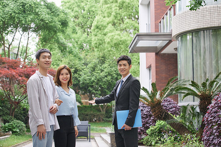 房地产销售人员向新婚夫妻介绍房源楼市高清图片素材