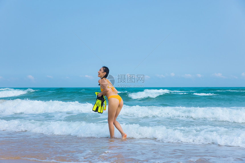 夏日比基尼美女拿着浮潜装备走向大海图片