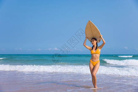 夏日海边比基尼美女头顶冲浪板图片