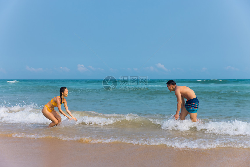 年轻泳装情侣海边戏水打闹图片