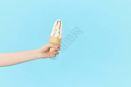 手拿甜筒女性手拿冰淇淋甜筒特写背景