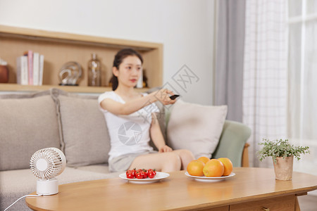 夏日美女居家生活拿遥控器看电视亚洲人高清图片素材