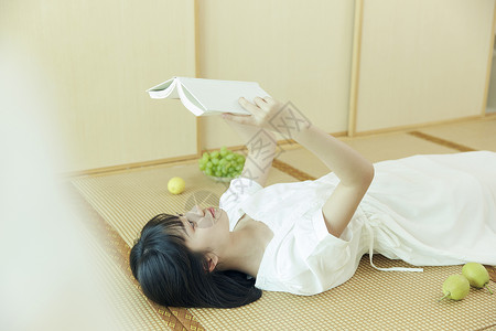 日系清新美女躺着看书图片