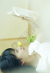 日系清新美女躺着看书背景图片