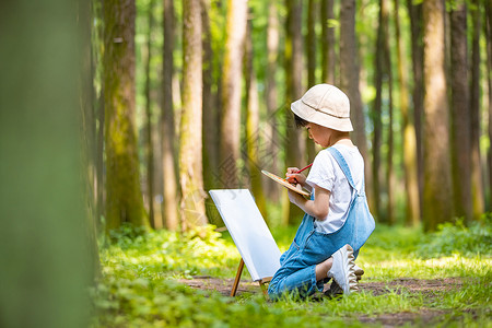 在画画的儿童小男孩在树林里画画背景