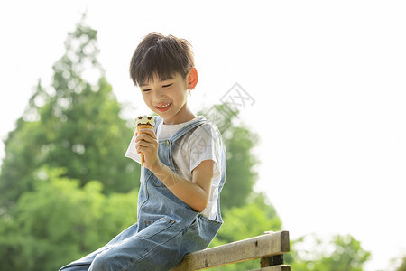 小孩吃冰激凌小男孩在户外悠闲吃冰淇淋背景