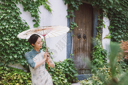 中国风庭院旗袍美女撑油纸伞跳舞背景图片