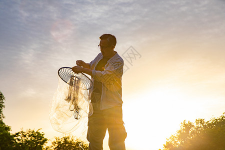 夕阳下捕捞的渔民图片