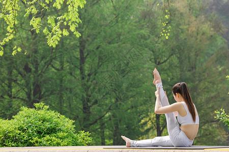 女性在公园里做瑜伽拉伸腿部图片