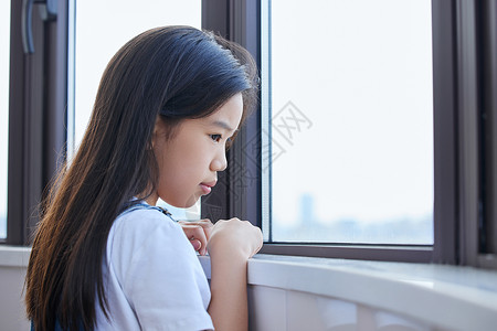 趴在窗前表情难过的小女孩图片