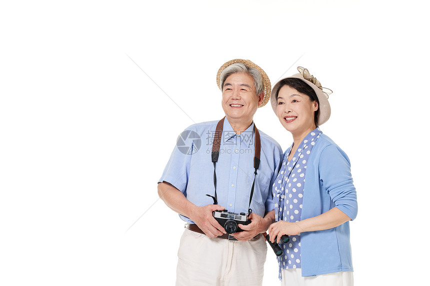 拿着相机旅行的退休老年夫妻图片
